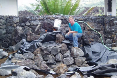 Hawaii5024I - A large rock waterfall in the middle of a swimming pool surrounded by lush greenery