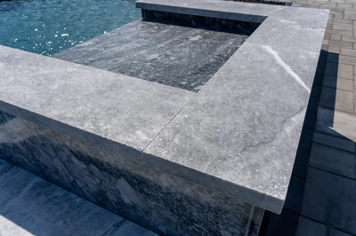 Haymeadow F - Mullica Hill, NJ - A close-up view of a concrete bench by a swimming pool.