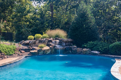 Hemlock D - East Petersburg, PA - A swimming pool with a waterfall in the middle surrounded by lush greenery