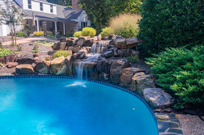 Hemlock F - East Petersburg, PA - A swimming pool with a waterfall in the middle surrounded by lush greenery
