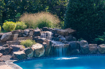 Hemlock I - East Petersburg, PA - A swimming pool with a waterfall in the middle surrounded by lush greenery