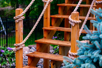 Horsetail J - Marlton, NJ - A wooden climbing frame with ropes and plants in a garden setting