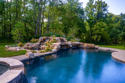 Howick F - Ivyland, PA - A swimming pool surrounded by lush green trees and a waterfall.