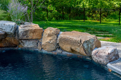 Howick H - Ivyland, PA - A swimming pool surrounded by lush green grass and a black fence.