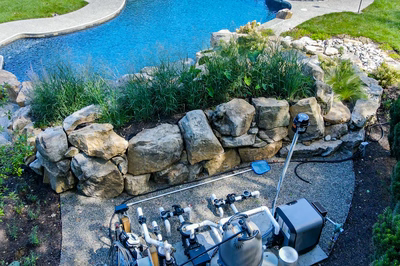 Howick M - Ivyland, PA - A backyard with a swimming pool surrounded by rocks and plants.