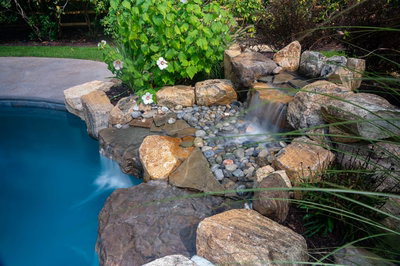 Jodo C - Medford, NJ - A small waterfall in a rock garden next to a swimming pool