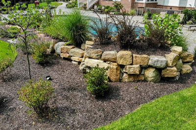 Jodo F - Medford, NJ - A well-maintained garden with a retaining wall and a pool in the background