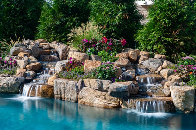 Joren B - Long Beach Island, NJ - A beautiful garden with a small waterfall surrounded by lush greenery and colorful flowers