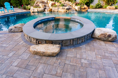 Joren H - Long Beach Island, NJ - A swimming pool with a fire pit in the middle surrounded by rocks and plants