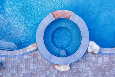 Joren I - Long Beach Island, NJ - A blue swimming pool with a stone edge and a wooden deck, viewed from above