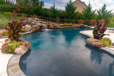 Juba F - Flemington, NJ - A beautiful backyard with a swimming pool surrounded by lush greenery and colorful flowers