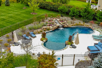 Juba I - Flemington, NJ - A backyard with a swimming pool surrounded by lush greenery and landscaping