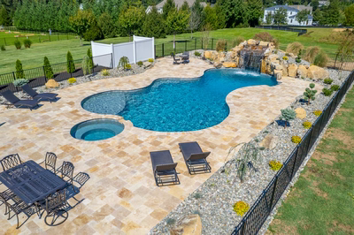 Kamui K - Phoenix, MD - A large backyard with a swimming pool and a waterfall.