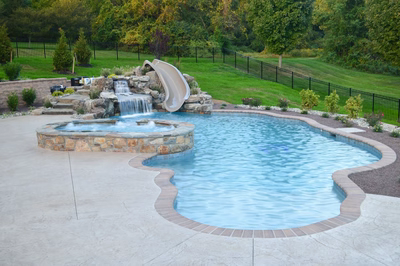 Kedron F - Thorton, PA - A swimming pool with a waterfall and a slide in a backyard setting