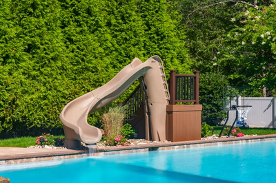 Lamberson B - Mount Laurel, NJ - A backyard with a pool and a water slide surrounded by lush green hedges