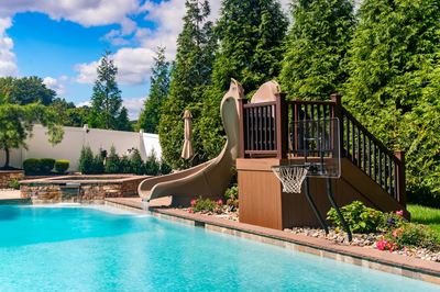 Lamberson E - Mount Laurel, NJ - A backyard with a pool and a basketball hoop and a slide