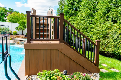 Lamberson F - Mount Laurel, NJ - A wooden deck next to a swimming pool surrounded by greenery and flowers