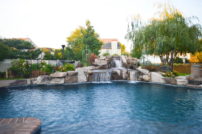 Lisbon H - Marlton, NJ - A swimming pool with a waterfall in the middle surrounded by lush greenery