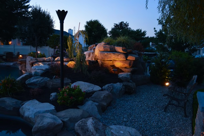 Lisbon K - Marlton, NJ - A rock garden with a waterfall and a bench at night