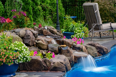 Manido C - Matawan, NJ - A beautiful backyard with a swimming pool surrounded by lush greenery and colorful flowers