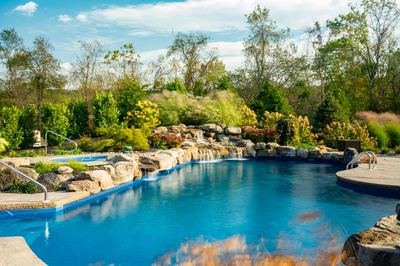 Morris W - New Hope, PA - A blue swimming pool surrounded by lush greenery and a waterfall.