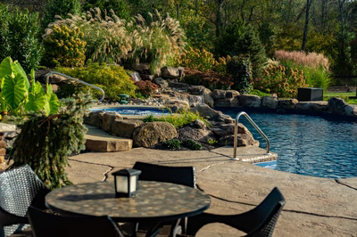 Morris W - New Hope, PA - A backyard with a swimming pool surrounded by lush greenery and rocks