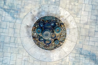 Maruyama - New Hope, PA - A circular stone fountain surrounded by pebbles on a tiled surface