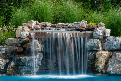 Masinga - Lumberton, NJ - A small waterfall cascades over rocks into a pool surrounded by lush greenery