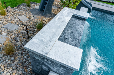 Memorial L - Cherry Hill, NJ - A modern swimming pool with a waterfall feature surrounded by rocks and grass