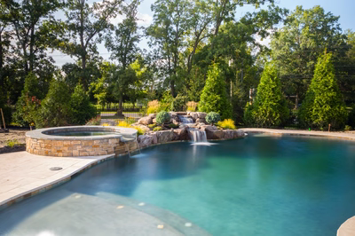 Mesa B - Mt. Laurel, NJ - A swimming pool with a waterfall in the middle surrounded by lush greenery