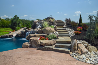 Miners E - Flemington, NJ - A large rock garden with a waterfall and steps leading to a swimming pool