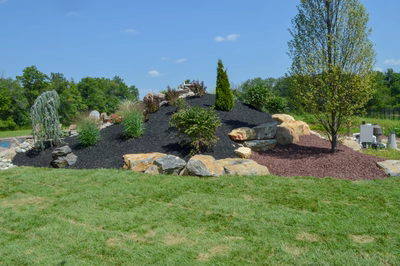 Miners G - Flemington, NJ - A rock garden with a fountain in the middle of a grassy area