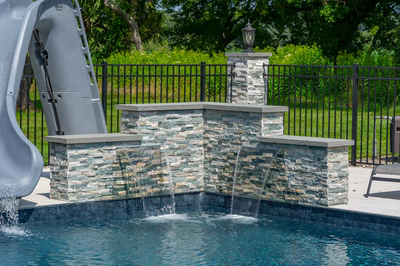 Mossbrae A - Millstone, NJ - A pool with a water feature and a water slide in a backyard setting
