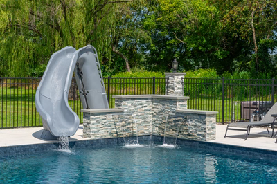 Mossbrae B - Millstone, NJ - A swimming pool with a water feature and a slide in a backyard setting