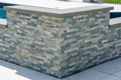 Mossbrae F - Millstone, NJ - A stone wall next to a swimming pool with a concrete countertop