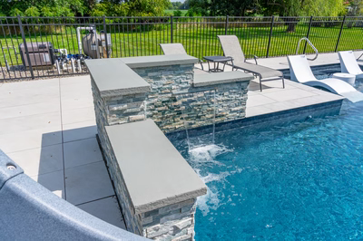 Mossbrae H - Millstone, NJ - A swimming pool with a waterfall feature and lounge chairs.