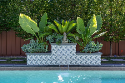 Murchison A - Point Pleasant, NJ - A water feature in the middle of a swimming pool surrounded by lush greenery