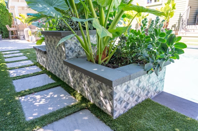Murchison F - Point Pleasant, NJ - A planter box filled with plants on a grassy area with stepping stones