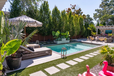 Murchison G - Point Pleasant, NJ - A backyard with a pool surrounded by lush greenery and tropical plants