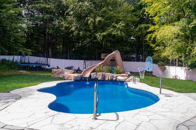 Myojin I - Sparta, NJ - A backyard with a swimming pool and a play area surrounded by trees