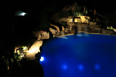 Myrtle I - Vineland, NJ - A swimming pool at night with a waterfall and a water feature illuminated by lights
