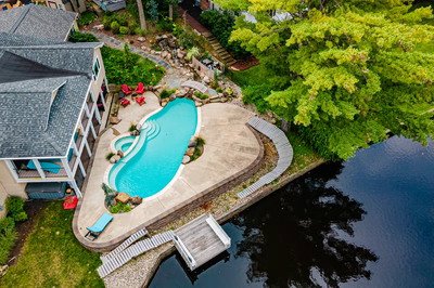 Nachi Y - Medford Lakes, NJ - A bird's eye view of a backyard with a swimming pool surrounded by lush greenery and trees
