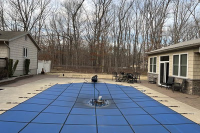 Naena A - Newfield, NJ - A blue tarp covering a concrete patio in a backyard setting.