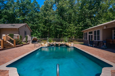 Naena B - Newfield, NJ - A backyard with a swimming pool surrounded by lush green trees
