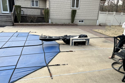 Naena C - Newfield, NJ - A person standing in front of a house with a blue tarp covering a patio area