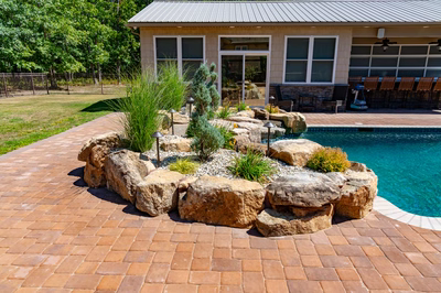 Naena I - Newfield, NJ - A brick patio next to a swimming pool with rocks and plants around it