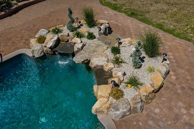 Naena L - Newfield, NJ - A bird's eye view of a swimming pool with a waterfall and landscaping around it