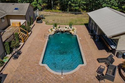 Naena O - Newfield, NJ - A backyard with a swimming pool and patio area surrounded by greenery