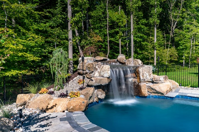Niagara E - Bel Air, MD - A swimming pool with a waterfall in the middle surrounded by lush greenery