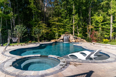 Niagara G - Bel Air, MD - A swimming pool surrounded by lush green trees and a waterfall.
